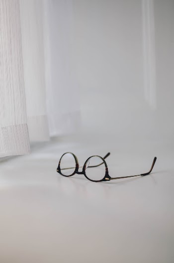 A pair of Ace & Tate glasses on a window sill. 
