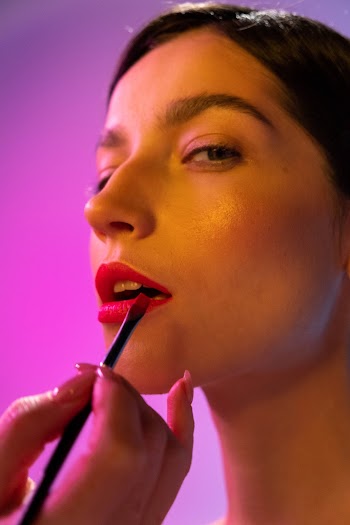 A Person Applying Lipstick to a Woman · Free Stock Photo