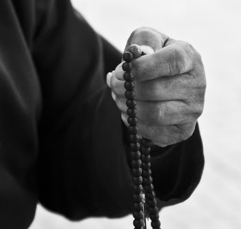 A person holding a beaded necklace