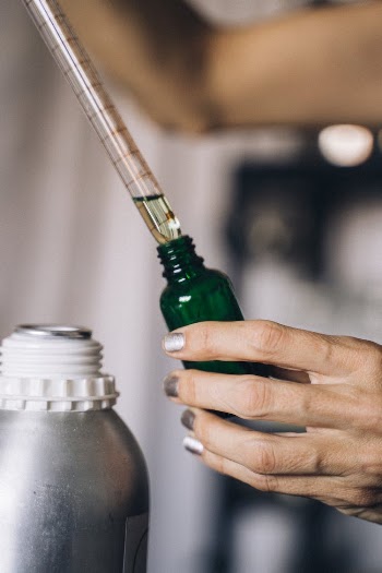 A Person Holding Green Glass Bottle