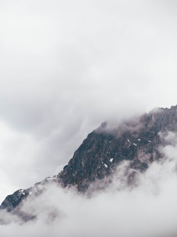 a photo of a mountain peak with fog