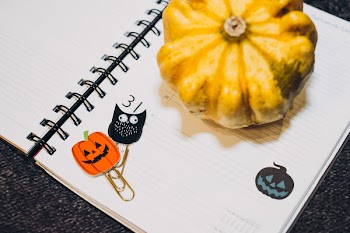 A pumpkin and an owl paperclips in a calendar