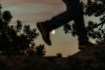 A rising moon being "kicked" by a passerby during a long sunset in Yosemite National Park.