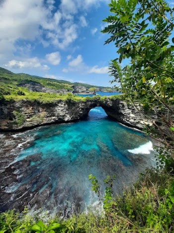 A Rock Formation Near the Body of Water Under the Blue Sky