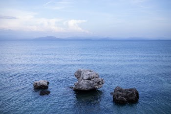 A Rock Formations on Water Under the White Clouds and Blue Sky