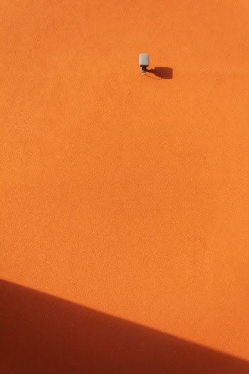 A Security Camera On An Orange Painted Wall