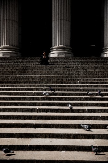A shot from New York City with a women sitting on stairs