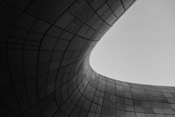 A smooth round curve in a gray building facade