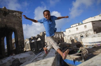 A Somali boy jumps between to old | Free Photo - rawpixel
