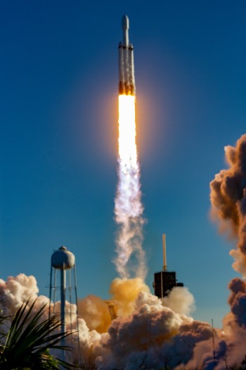 A sound-activated remote camera station placed northeast of Launch Complex 39-A captures the launch of the SpaceX Falcon Heavy on April 11, 2019. This view (water tower on the left and crew access tower on the right) is rare, as this is only the second time that SpaceX as opened the north-side camera locations.