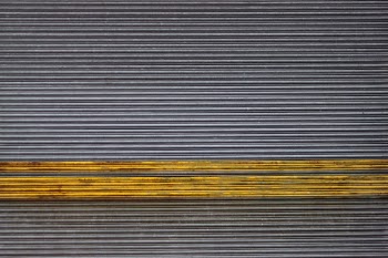 A striking industrial roller shutter door at a now demolished paper mill. The strong horizontal lines and bold yellow stripe of the grungy metal door was just too interesting for me not to capture.