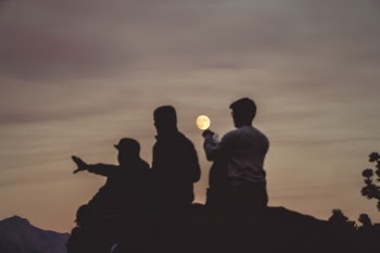 A sunset in Yosemite National Park gives the perfect backdrop for dramatic silhouettes. It took me more shots that I want to admit to pose the picture just right, so that it would look like one of the guys in it holds in the moon in his hand.