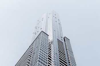 A tall skyscraper in Toronto against a pale blue sky