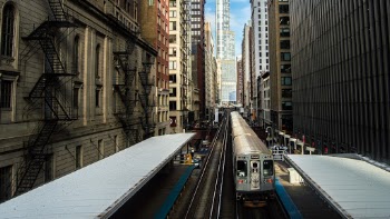A train departs a downtown stop midday in Chicago.