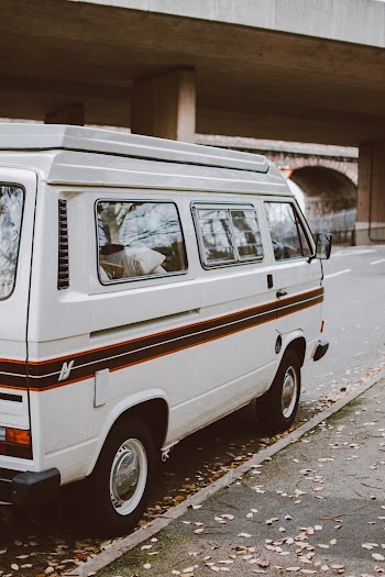 A White Van Parked On The Street Side Near Building