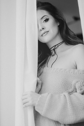 A woman peering through curtains 2