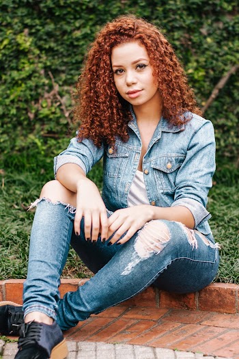 A woman with curly hair seated