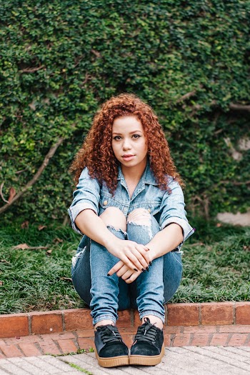 a woman with curly hair sitting down
