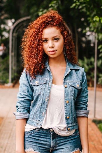A woman with curly hair wearing denim