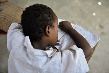 A young boy writes in his | Free Photo - rawpixel