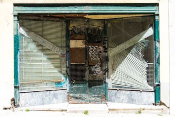 abandoned building with white venetian blinds on window