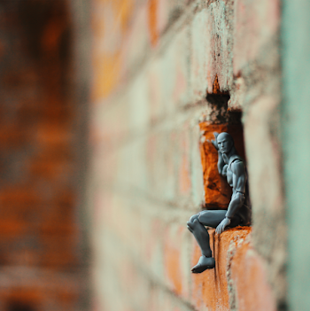 Action Figure on a Hole of Brick Wall