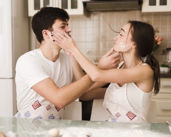Adorable young man and woman playing with food Free Photo