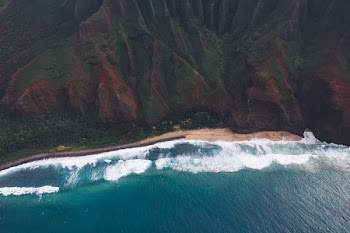 aerial photo of blue body of water and tree covered mountain