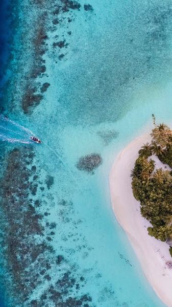 aerial photo of boat moving towards the white island during daytime