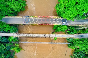 Aerial Photo of Bridge over River With Murky Flood Water
