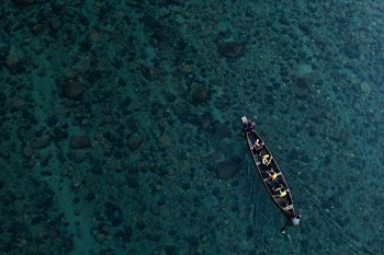 aerial photo of canoe on calm water with people