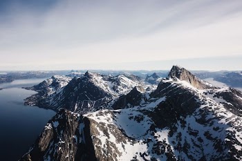 aerial photo of glacier mountain near body of water during daytime
