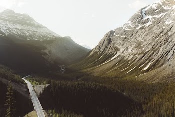 aerial photo of gray alphated road near mountain