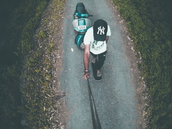 Aerial Photo of Man Taking Photo on Green Motor Scooter