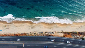 aerial photo of vehicles on road near beach