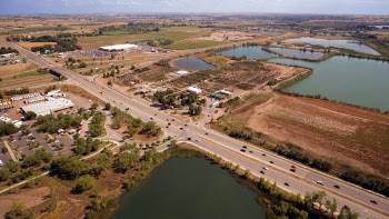 Aerial Photography of an Open Road With Cars Near City and Lake during Daytime