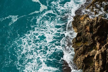 Aerial Photography of Body of Water Beside Rock Formation