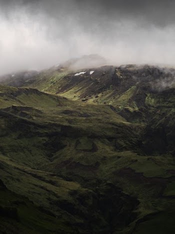aerial photography of green mountain under cloudy sky