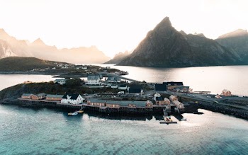 aerial photography of houses surrounded with body of water and mountains