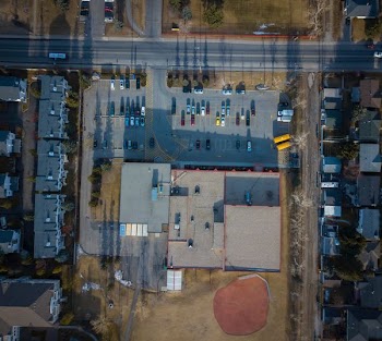 aerial photography of large building with vehicles on parking lot during daytime