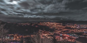aerial photography of lighted buildings under cloudy sky at night