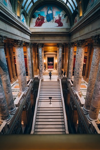 Aerial Photography of Man Standing on Top of Staircase Inside a Cathedral