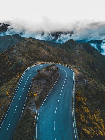 aerial photography of mountain pass under white clouds