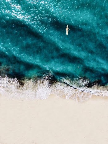 aerial photography of person doing surfboard on body of water at daytime