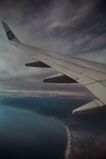 aerial photography of plane wing and body of water