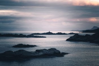 aerial photography of rock formation on body of water