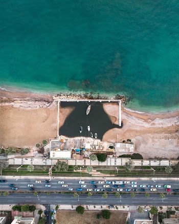 aerial photography of seashore near buildings and concrete road top during daytime
