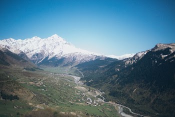Aerial Photography of Valley and Snow Capped Mountains