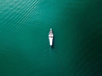 aerial photography of white boat on the middle of calm water
