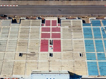 aerial photography of white, red, and blue chairs near black concrete race track